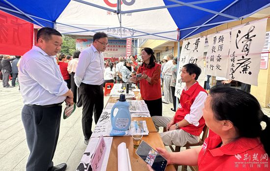 “文化惠民”攤位上，志愿者展示書(shū)法作品_副本.jpg